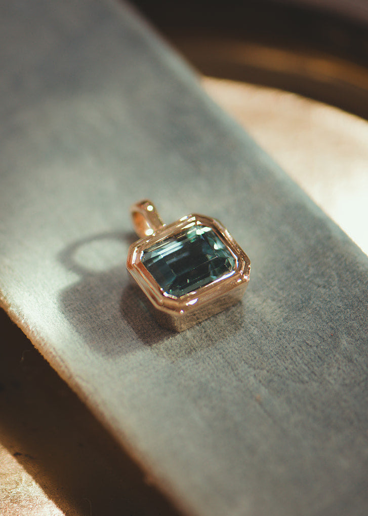 Solid yellow gold pendant with a blue aquamarine gemstone