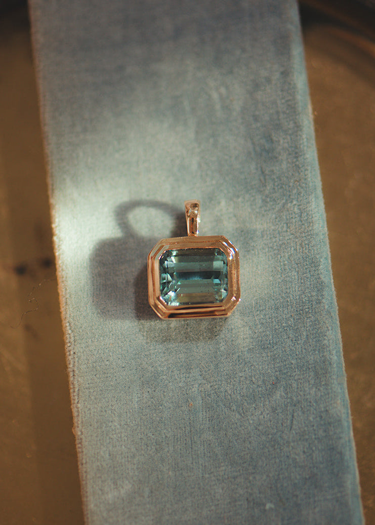 Solid gold pendant with a blue aquamarine gemstone